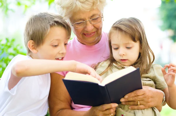 Grandmother reading a book for grandchildren