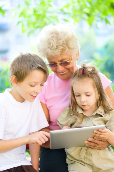 Grandmother with grandchildren using tablet