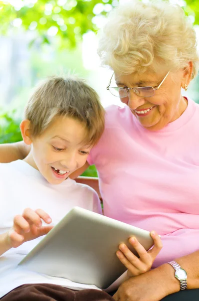 Boy with his grandmother using tablet