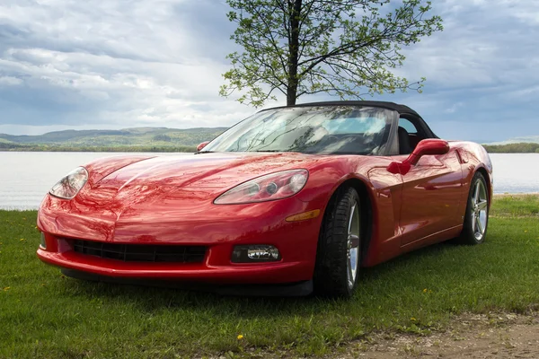 Red sport Chevrolet Corvette 2005 car in front of a lake