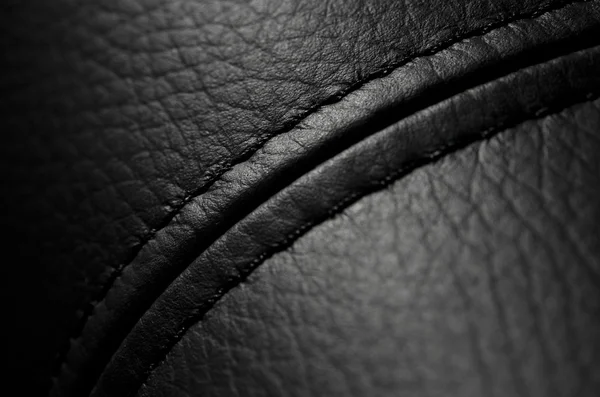 Black dark leather background or texture with sewing.