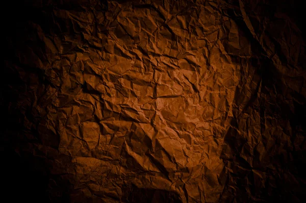 Brown paper background with dark creased patterns and vignette.