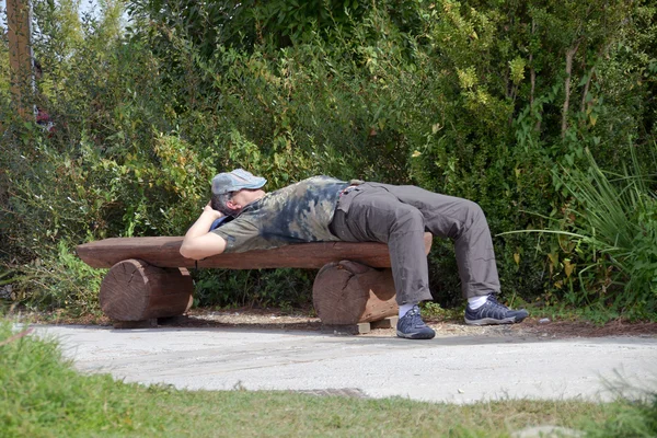 Sleeping man lying on a bench