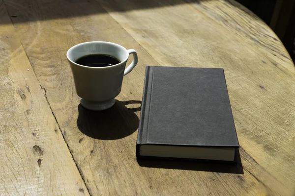 Black Book and Black Coffee on Wooden Table