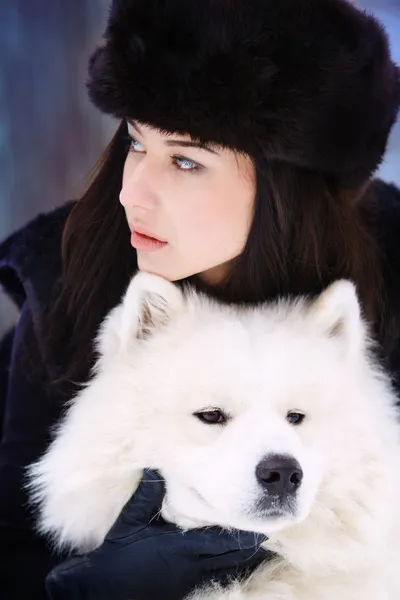 Young beautiful woman in winter forest with dog