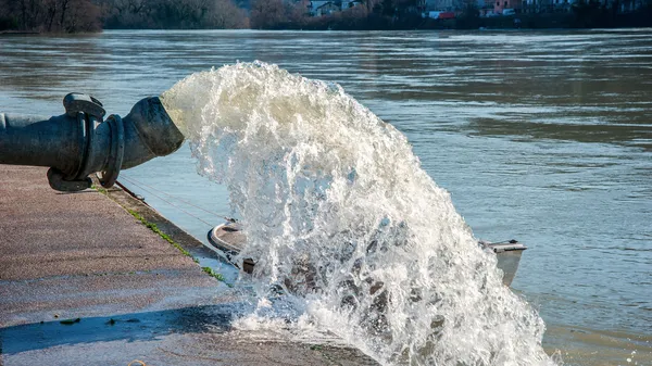 Flood water being pumped from pump station into river