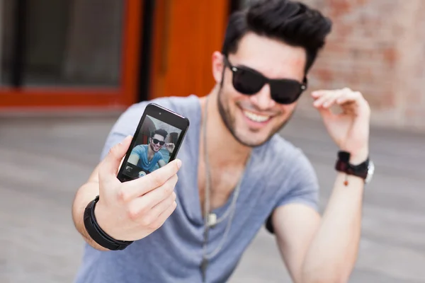 Young male model making self portrait with a smartphone