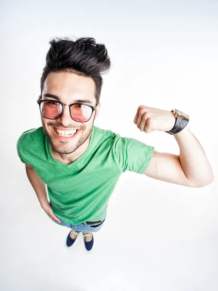 Funny handsome man with hipster glasses showing muscles - wide angle shot