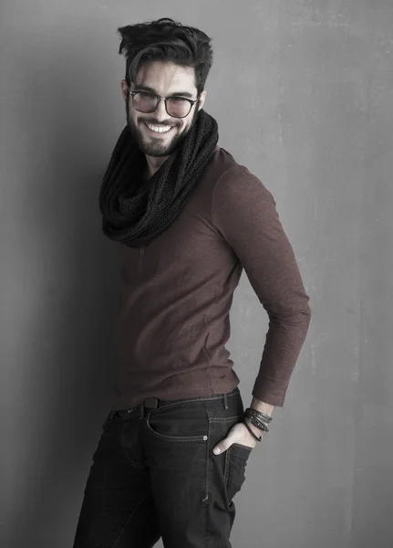 Sexy fashion man model dressed casual smiling against wall