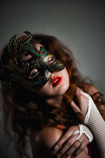 Beautiful Girl in Carnival mask with long curly hair. Masquerade Holidays