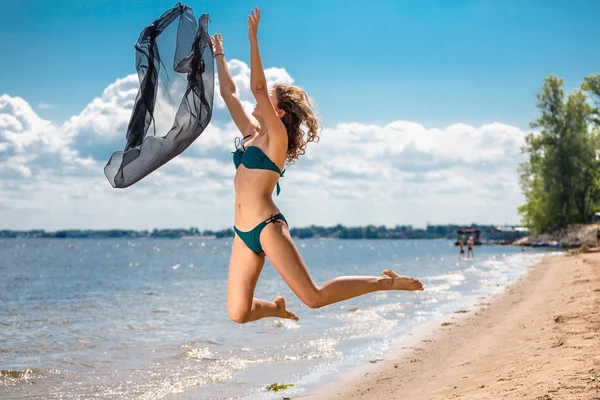 Jumping happy girl on the beach, fit sporty healthy sexy body in bikini