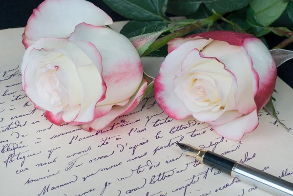 Old letter, pen and and two roses