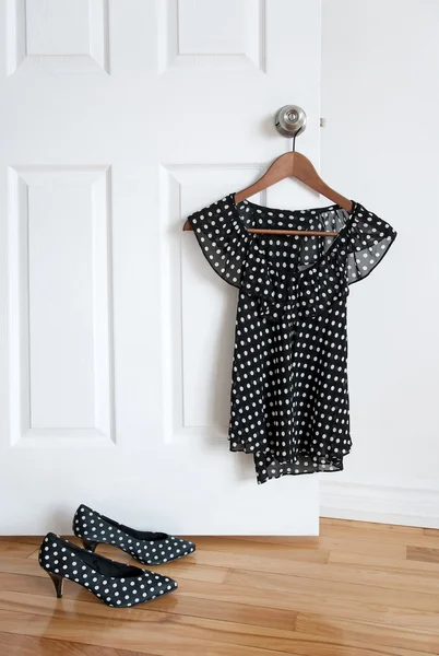 Polka dot shoes and stylish blouse on a hanger