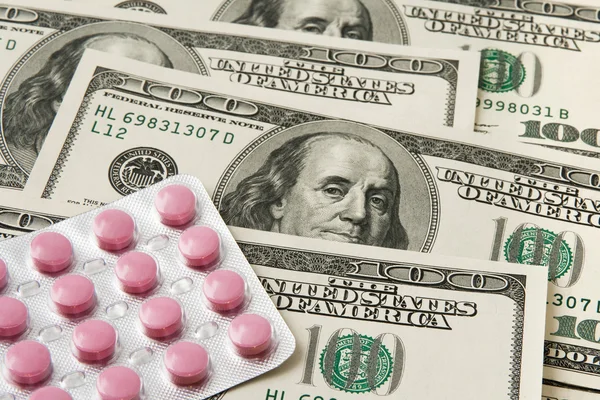Pills package on money background
