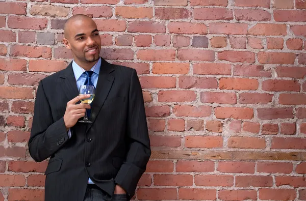 Smiling young business man drinking wine