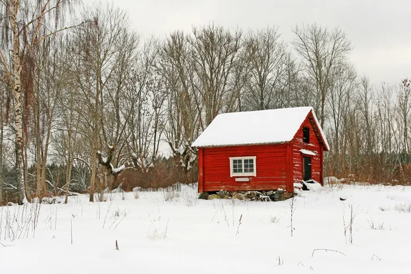 Traditional Swedish red wooden house in snow