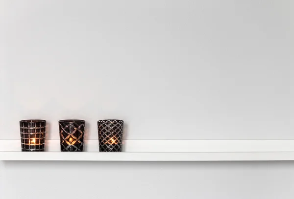 Candle lights on white shelf