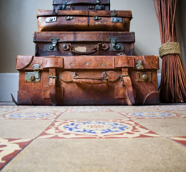 Stack of Old Leather Luggage on Tiled Floor