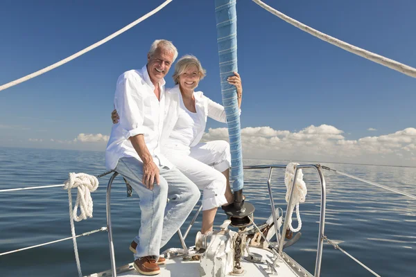A happy senior couple embracing at the front or bow of a sail boat
