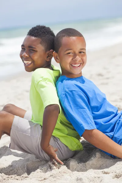 Young African American Boys Sitting Playing on Beach