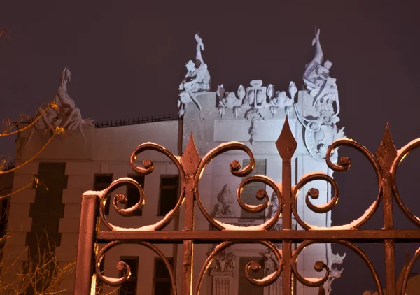 House with chimaeras through the fence