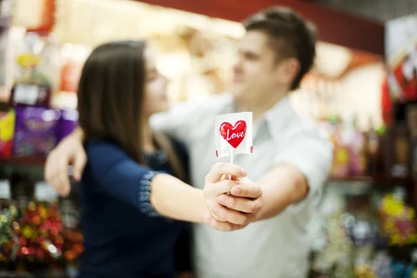 Couple holding lollipop in their hands
