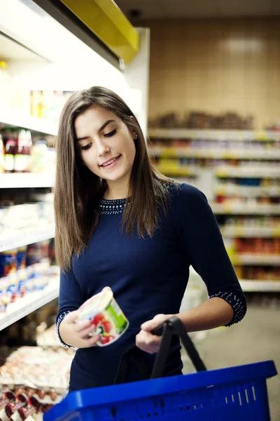 Woman choosing yogurt in supermarket