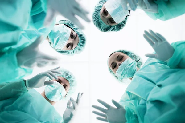 Surgeons standing above of the patient before surgery