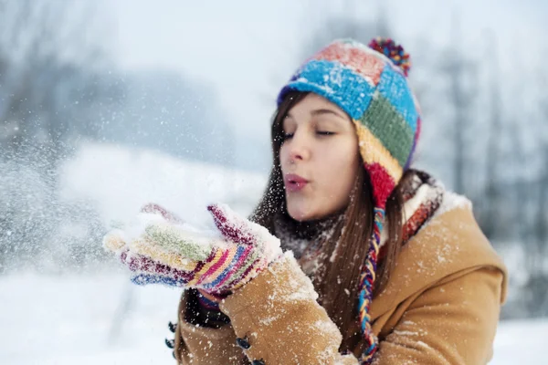 Woman blowing snow to away