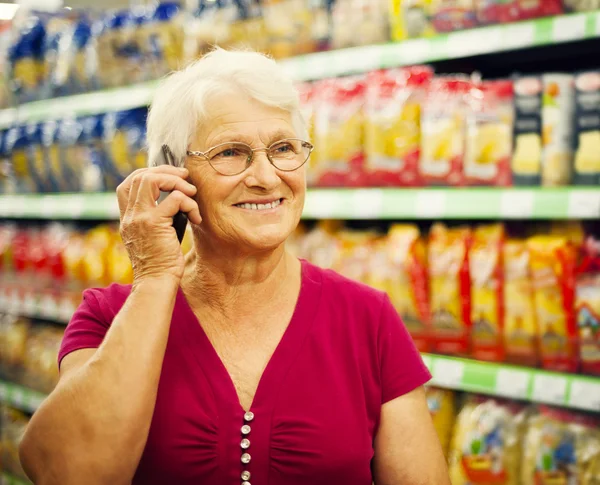 Senior woman at supermarket — Stock Photo #21915769