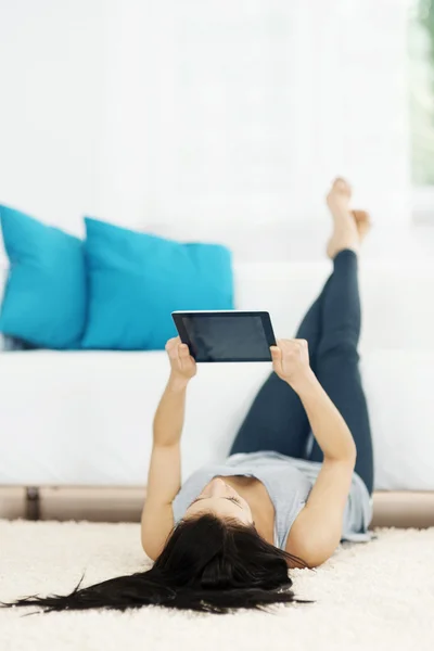 Young woman using tablet on the floor