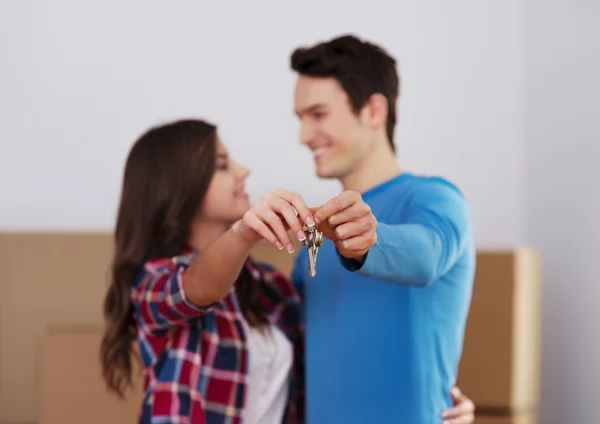 Young couple holding key to new home in hand