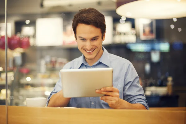 Smiling man using digital tablet