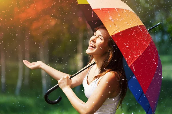 Woman with umbrella checking for rain