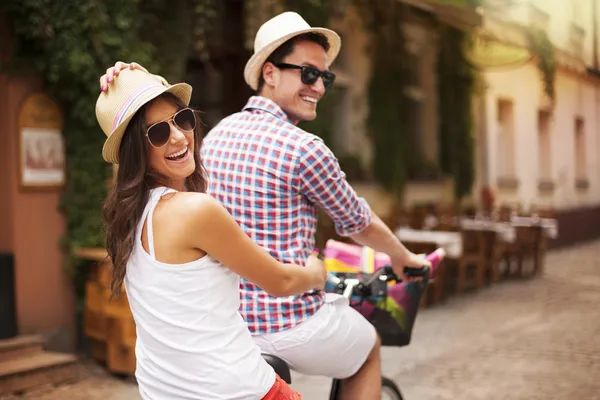 Happy couple riding a bicycle in the city street