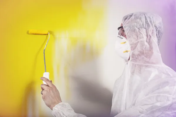 Painter painting wall yellow