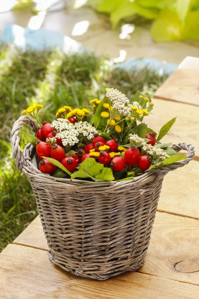 Bouquet of autumn plants in wicker basket. Garden party decor