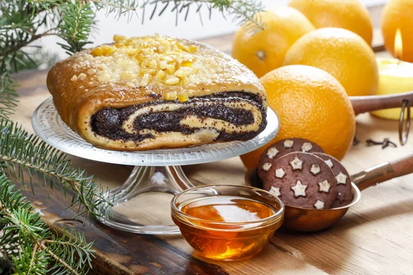 Poppy seed cake on glass cake stand under fir branch. Christmas