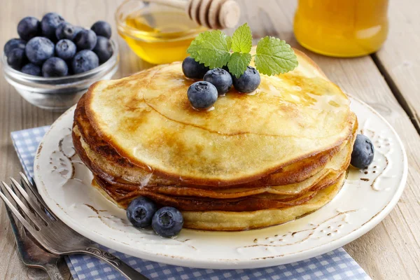 Stack of pancakes with syrup and blueberries