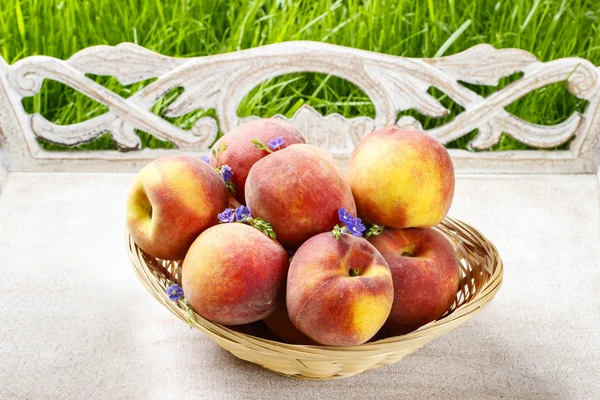 Basket of peaches on wooden tray. Summer garden party idea