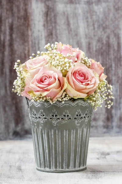 Bouquet of pink roses in rustic bucket