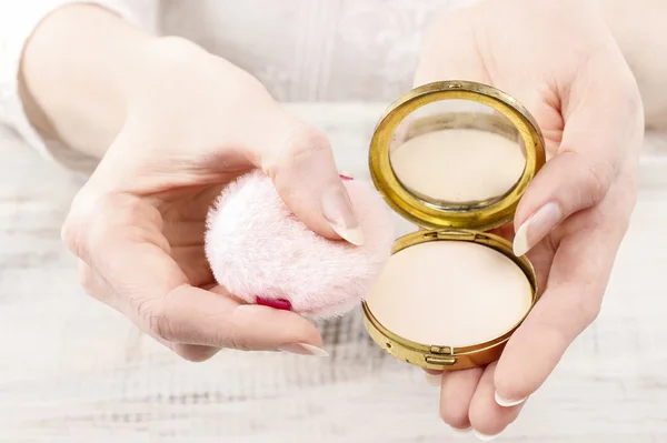 Woman holding vintage compact powder in beautiful hands