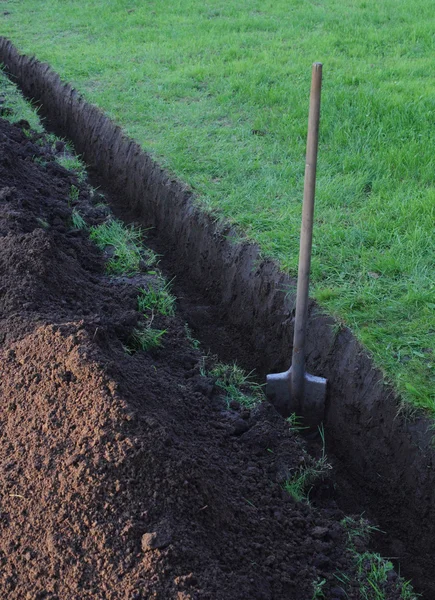 Trench in the ground and the spade