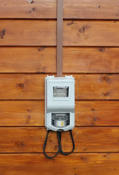 Electricity supply meter on wooden wall front view