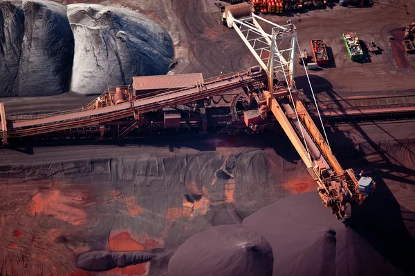 Conveyor belt carrying coal and emptying onto a huge pile
