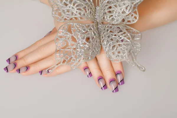 Female hands with beautiful manicure in gentle tones.