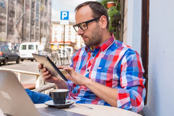 Man using tablet and drinking coffee