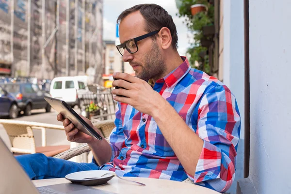 Man using tablet and drinking coffee