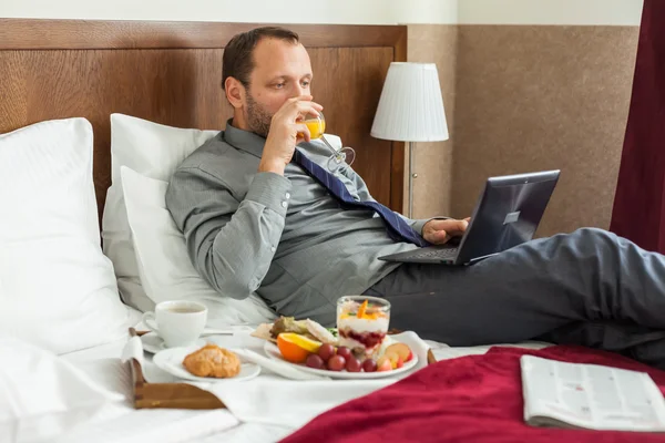 Businessman using laptop during breakfast