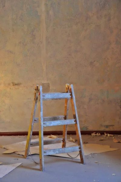 Torn wallpaper and a wooden ladder